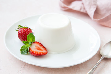 Panna cotta, traditional italian dessert, served with fresh strawberry and mint