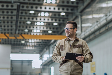 Portrait of a smiling foreman at work in industrial building.