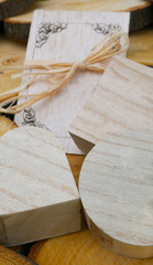 Wooden greeting card and a closed gift boxes of different shapes on wooden stump