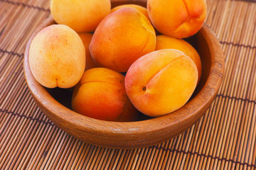 Organic apricots in a wooden bowl