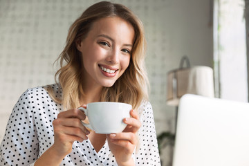 Beautiful young blonde woman sitting at the cafe