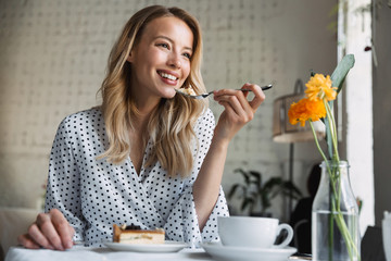 Beautiful young blonde woman sitting at the cafe