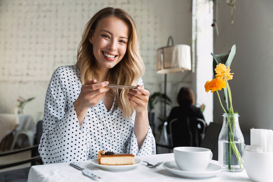 Beautiful young blonde woman sitting at the cafe