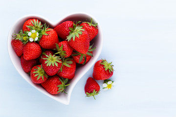 Strawberry heart. Fresh strawberries in plate on white wooden table. Top view, copy space.