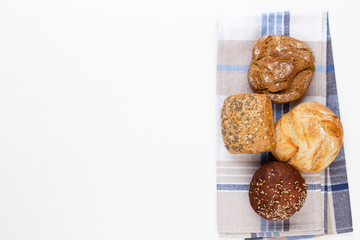 Gold rustic crusty loaves of bread and buns on wooden background. Still life captured from above top view, flat lay.