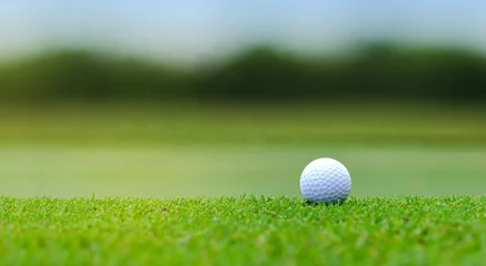 Gordijnen White Golf ball on green course to be shot on blurred beautiful landscape of golf course in bright day time with copy space. Sport, Recreation, Relax in holiday concept  © Nischaporn