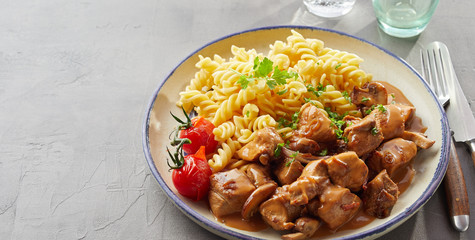 Herbs atop dish of spiral pasta and beef