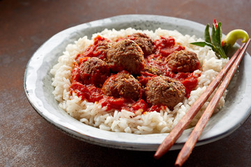 Angled close up on meatballs bowl containing thai rice