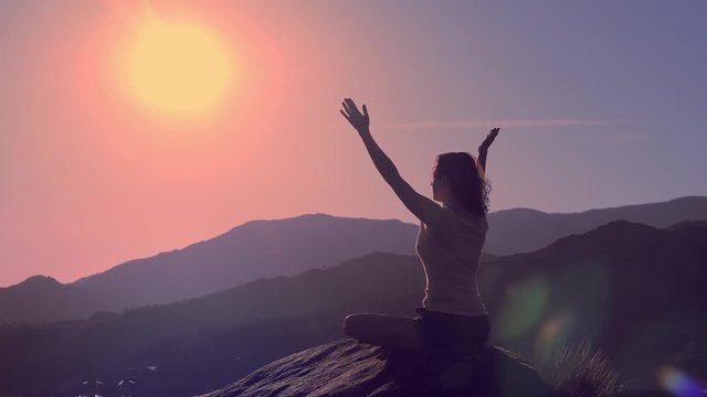 Young practicing woman practice yoga on mountain peak