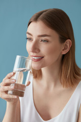 Drink water. Smiling woman drinking water from glass portrait