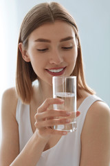 Drink. Woman drinking fresh pure water from glass portrait