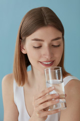 Drink water. Smiling woman drinking water from glass portrait