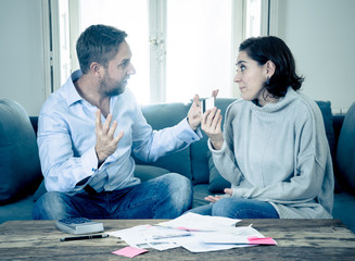 Stressed young couple having an argument over credit car debts payments and home finance