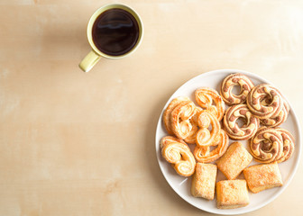 Shortbread cookies and cup with coffee on wooden table