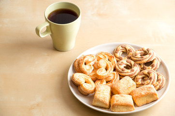 Shortbread cookies and cup with coffee on wooden table