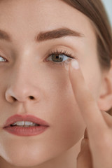 Contact eye lens. Woman applying eye contacts on eyes closeup