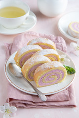 slised strawberry swiss roll  cake on white plate