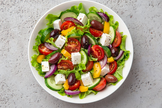 fresh greek salad ( tomato, cucumber, bel pepper, olives  and feta cheese) in white bow