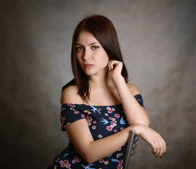 Beautiful brunette woman in sundress on grey background.