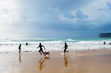 Fototapeta na wymiar Silhouette people dog beach Portugal