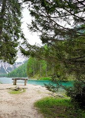Empty wooden bench on the shore of the mountain lake, lake Braies, Dolomites, Italy. 