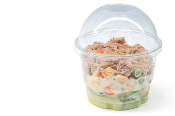 Salad vegetables with tuna in plastic box isolated on white bowl.