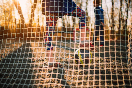 Two children playing football at sunset, United States