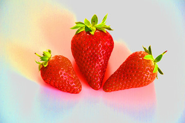 Top view of three red strawberries on white plane 