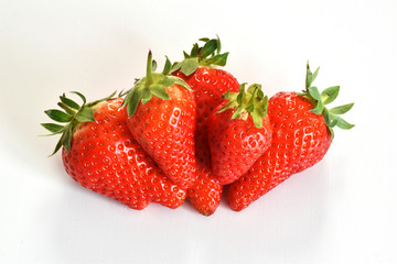 Top view of a group of red strawberries on a white floor 