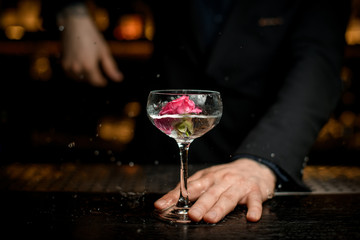 Bartender throwing flower in an alcohol cocktail