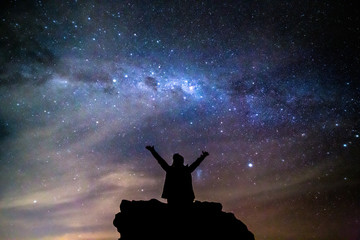 Silhouetted person hails the cosmos milky way starry night sky - 274227101
