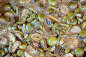 Green eggplant and green beans soup, boiled in big pot, Thai style food. Street food in local market, Thailand, closeup