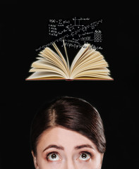 The girl thinks and looks at the open book