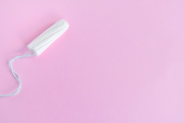 Soft cotton tampon for women period days with selective focus on blurred pink background. Hygiene products for women's monthly menstruation. White protection tampons for female health care. 