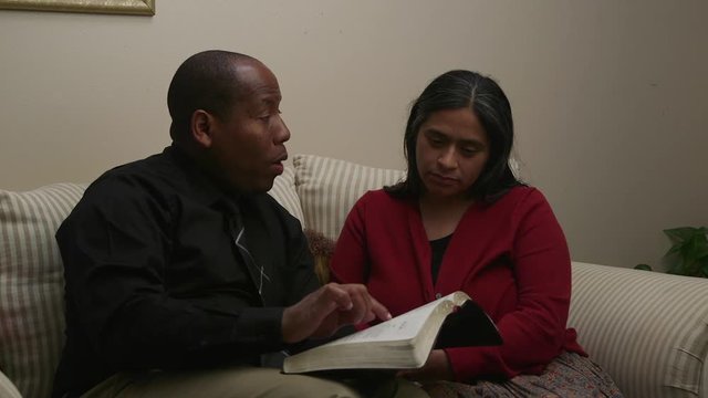 Mix Christian Couple Having Bible Study At Home