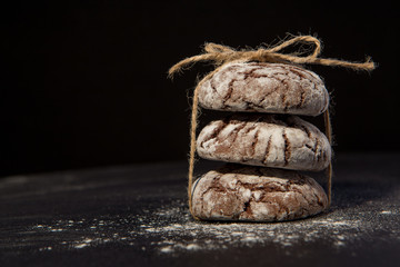 Stacked chocolate chip cookies on black background, sweet dessert, selective focus.