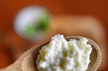 Close-up shot of a wooden spoon full of Kefir granules