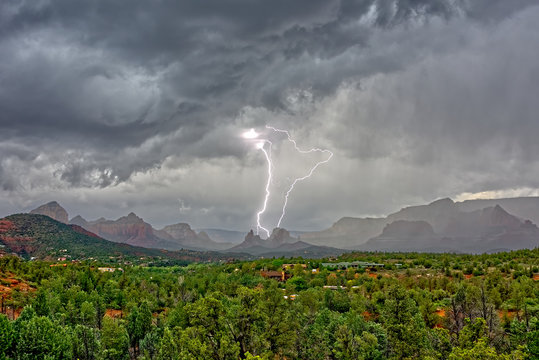 Lightning striking Cibola Rock in the Uptown area of Sedona Arizona. Viewed from the Broken Arrow Trail.