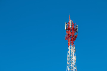 Wireless Communication Antenna Transmitter. Telecommunication tower with antennas on blue sky...