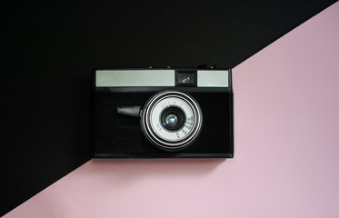 Film retro camera on a black and pink background 8