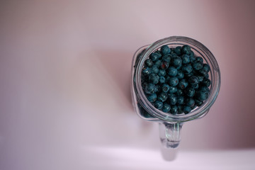 Jar of blueberries on a pink background 7