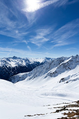 Fototapeta na wymiar Bergige Landschaft mit Schnee und blauem Himmel in den Alpen