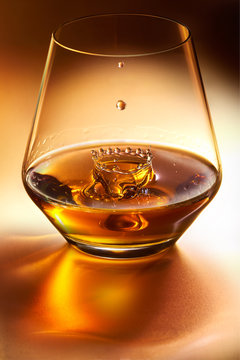 whisky drop falling into glass of whisky