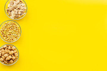 Cereals and flakes from corn and oat on yellow background top view mockup