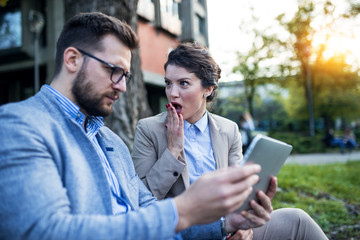 Shocked business people looking at tablet