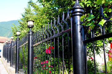 Garden fence made of iron in black.  Wrought iron tracery black fence fragment 