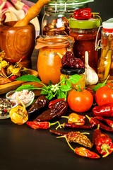 Homemade chili sauce. Spicy food. Chili peppers on black background. Bhutjolokia hot chilli pepper. Healthy food.