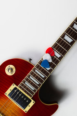 Les Paul style electric guitar with red, white and blue picks. White Background.