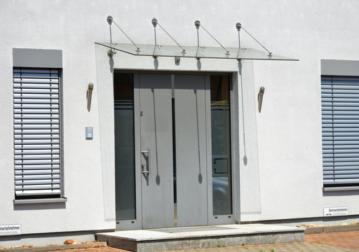 Moderner Hauseingangsbereich mit Glas-Vordach an einem neu gebauten Mehrfamilien-Wohnhaus mit B&uuml;ros