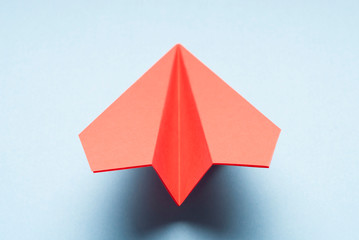 Origami plane on blue background.